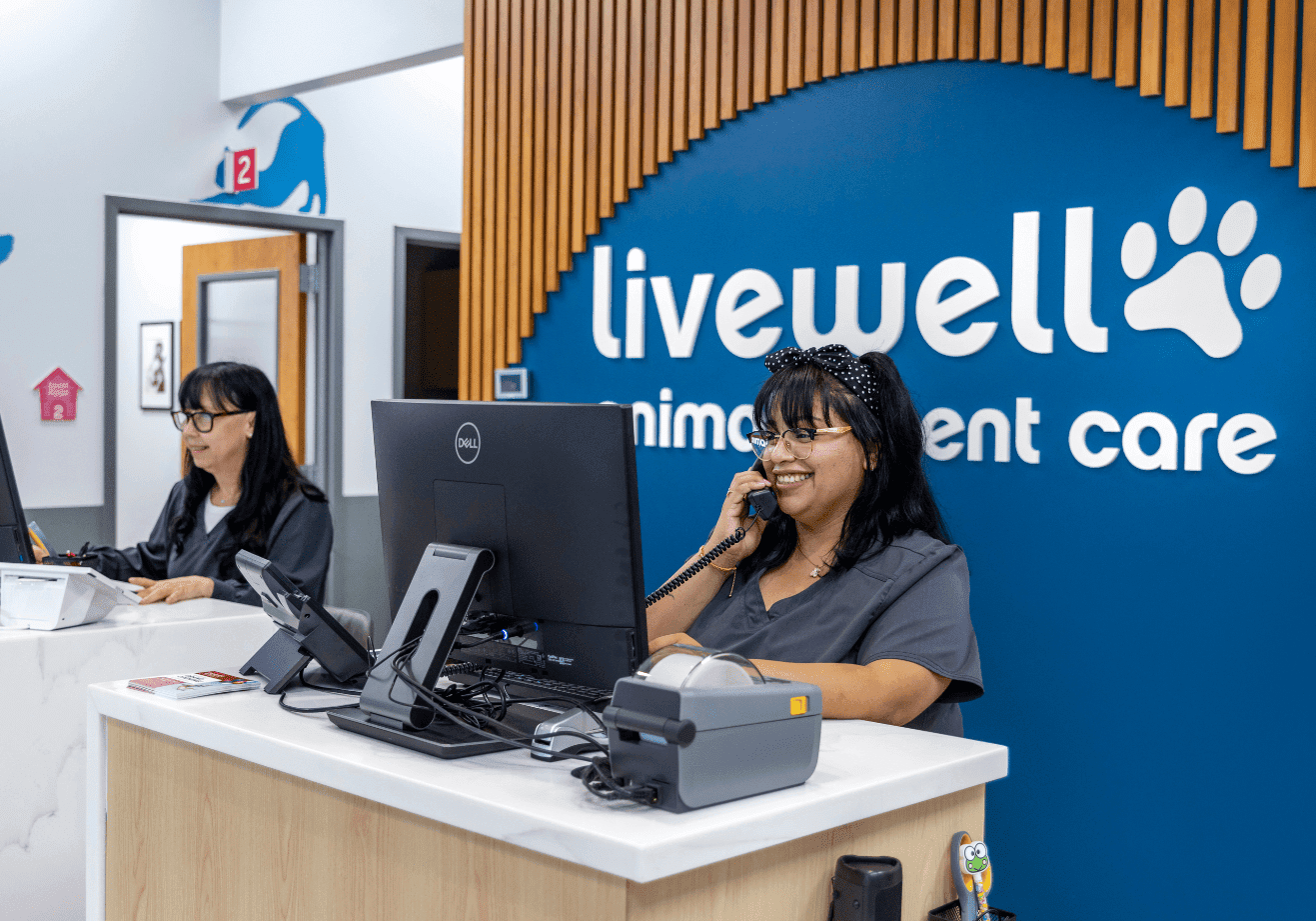 Two receptionist at desks, one answering phone call